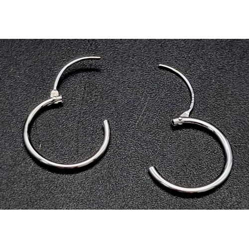 818 - A 9 K white gold pair of sleeper earrings. Weight: 0.3 g.