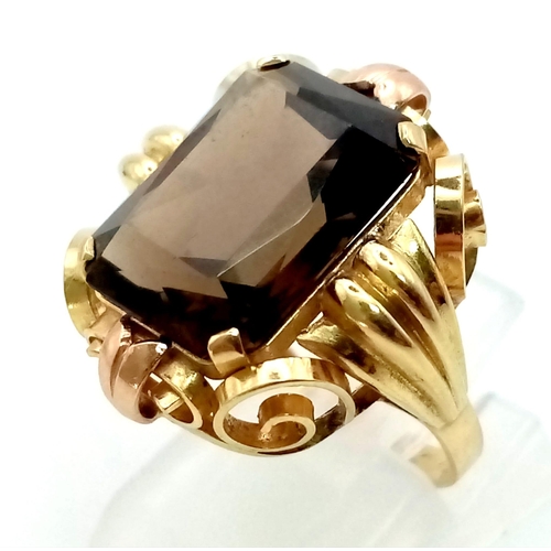 401 - A 1940s 14K Yellow Gold Smoky Quartz Cocktail Ring. A large emerald cut smoky gemstone housed in a s... 