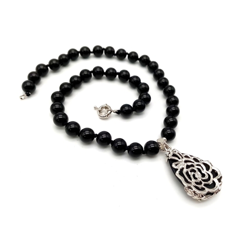 735 - A Black Onyx Agate Beaded Necklace and Teardrop Pendant. 10mm beads. Pendant - 4cm. Necklace - 44cm.