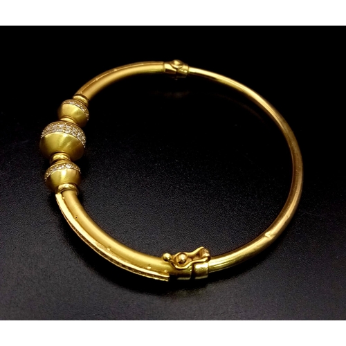 169 - A 21k Yellow Gold and White Stone Decorated Bangle. Clasp opening. 58mm inner diameter. 16.5g total ... 