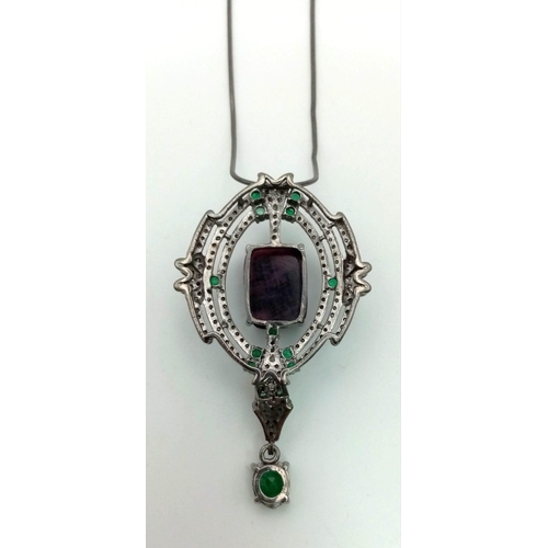 352 - A floral carved Ruby and Emerald Drop Pendant set in 925 silver, decorated with Diamonds. 
10cts Rub... 