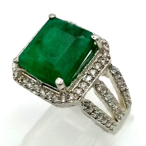 540 - A 7ct Natural Emerald ring set in 925 silver decorated with white stone surround. Size V. Comes with... 