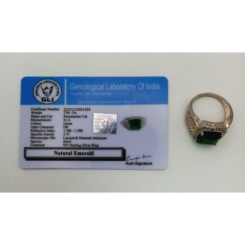 540 - A 7ct Natural Emerald ring set in 925 silver decorated with white stone surround. Size V. Comes with... 