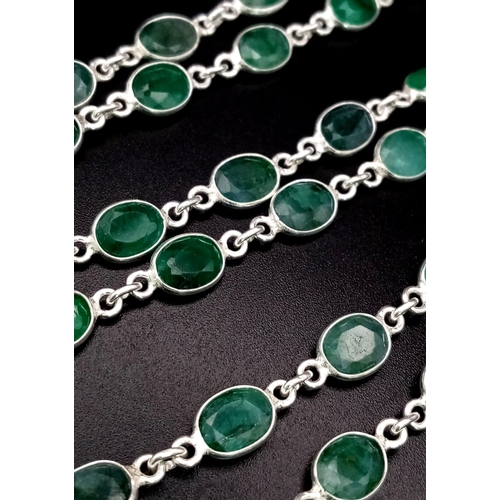 575 - An Oval Cut Emerald link Necklace set in 925 silver.  Length: 83cm. Total weight: 27.21g