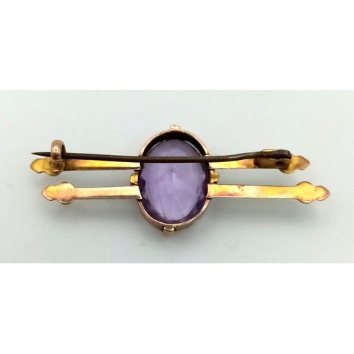 297 - A Victorian 9k gold amethyst brooch, stamped 9k. Width 46mm. Amethyst 16mm by 12mm. Weight 4.1g.