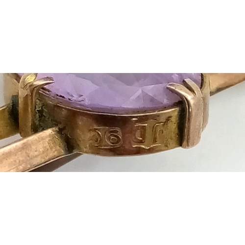 297 - A Victorian 9k gold amethyst brooch, stamped 9k. Width 46mm. Amethyst 16mm by 12mm. Weight 4.1g.