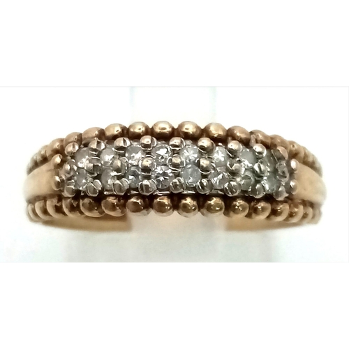 326 - A 9k gold band ring with beaded edging set with an estimated 0.20ct diamonds. Size P. Weight 2.6g