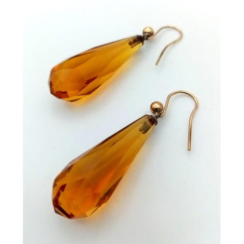 790 - A pair of 9k gold earrings set with amber-coloured pendulum droppers. Weight 6.63g total.