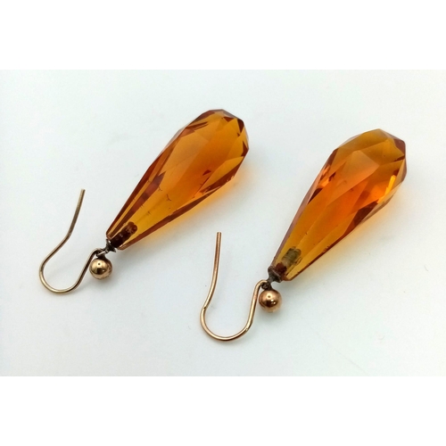 790 - A pair of 9k gold earrings set with amber-coloured pendulum droppers. Weight 6.63g total.