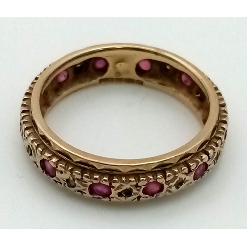 810 - A 9k gold ruby and diamond full eternity ring. Size N. Weight 3.7g.