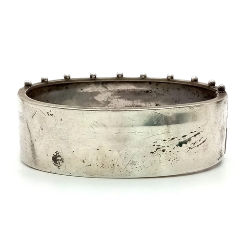 884 - A Victorian Sterling Silver Floral and Foliate Engraved Bangle. 17g. 23mm width.