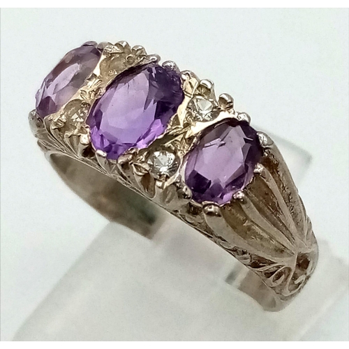 907 - A three-amethyst gemstone and cubic zirconia sterling silver ring. Size Q. Weight 3.4g total.