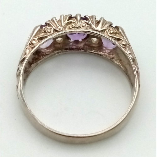 907 - A three-amethyst gemstone and cubic zirconia sterling silver ring. Size Q. Weight 3.4g total.