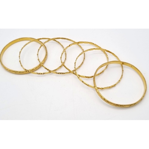 110 - A Mixed Gold Lot to Include: A 22K yellow gold selection of 10 bangles - 103.7g total weight - A/F. ... 