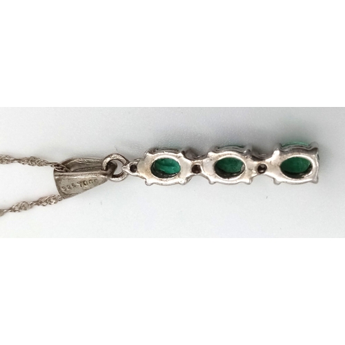 948 - A natural emerald and diamond trilogy 925 silver pendant and 18” Singapore twist chain. Emeralds mea... 