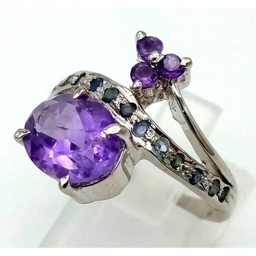 950 - An Amethyst and Sapphire Crossover Ring. In 925 Sterling Silver. Size P. 5.41g