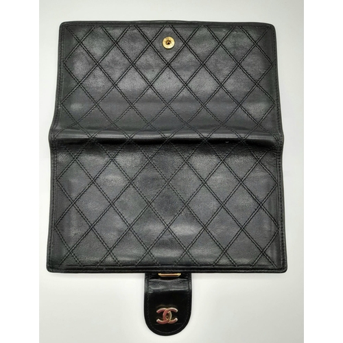 273 - A Vintage Chanel Black Leather Purse/Wallet. 17 x 10cm. Comes with a dust-bag. In good condition but... 