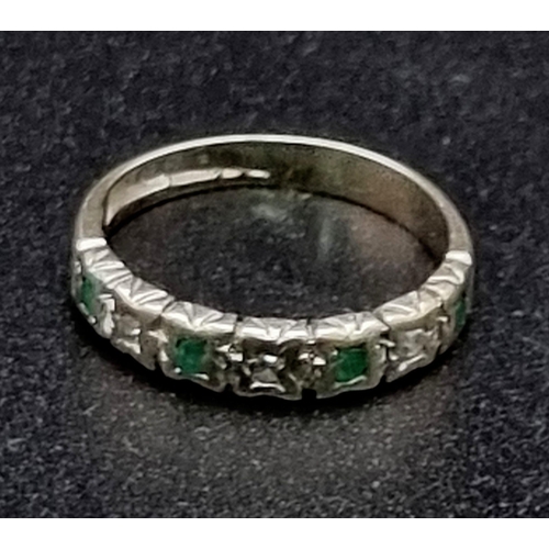 816 - A 9k white gold emerald and diamond half eternity ring, circa 1970’s. Size H. Weight 1.6g