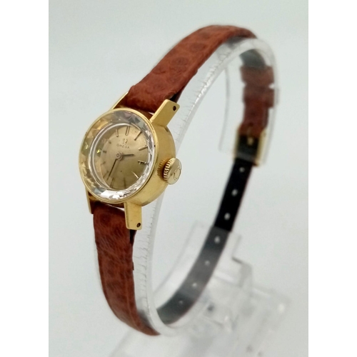 397 - A DAINTY VINTAGE 18K GOLD LADIES OMEGA WRIST WATCH ON THE ORIGINAL OMEGA LEATHER STRAP. MANUAL MOVEM... 