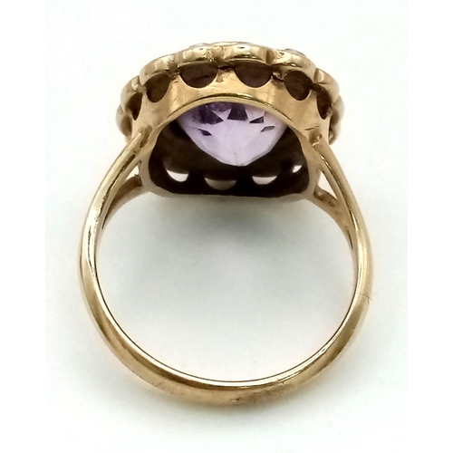 545 - A vintage, 9 K yellow gold ring with an oval cut amethyst surrounded by a halo of seed pearls. Ring ... 