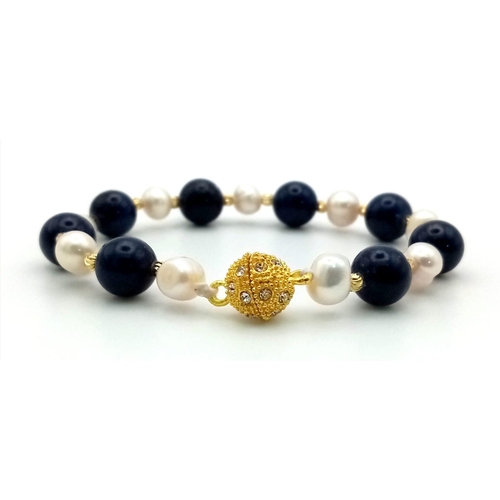 700 - A Freshwater Akoya Pearl and Lapis Lazuli Bead Bracelet. 6/8mm beads and pearls. Gilded spacers and ... 