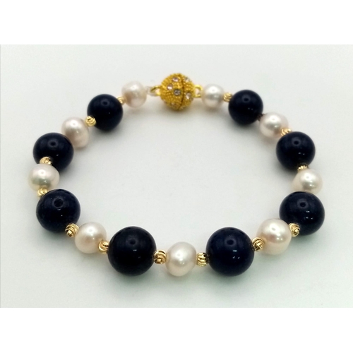 700 - A Freshwater Akoya Pearl and Lapis Lazuli Bead Bracelet. 6/8mm beads and pearls. Gilded spacers and ... 