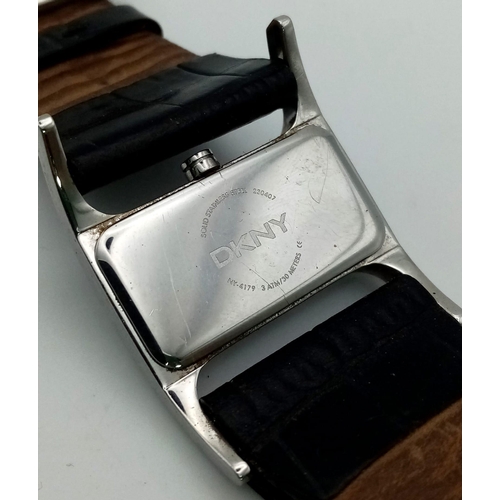 941 - DKNY black leather strap watch. As found.