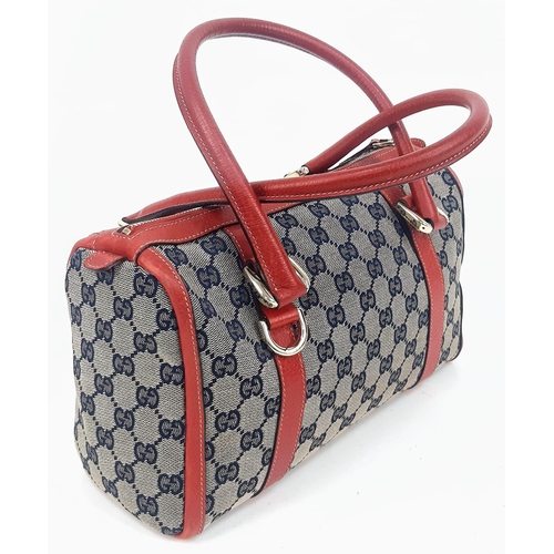 252 - A Gucci Monogram Canvas and Red Leather Boston Bag. Gilded hardware with zipped interior compartment... 