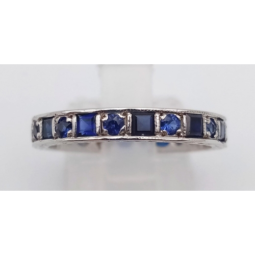 587 - A vintage 9 K white gold full eternity ring with round and emerald cut blue sapphires. Ring size: P,... 