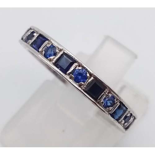 587 - A vintage 9 K white gold full eternity ring with round and emerald cut blue sapphires. Ring size: P,... 