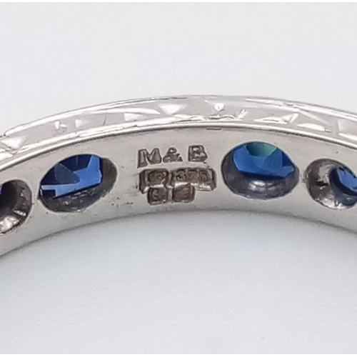 587 - A vintage 9 K white gold full eternity ring with round and emerald cut blue sapphires. Ring size: P,... 