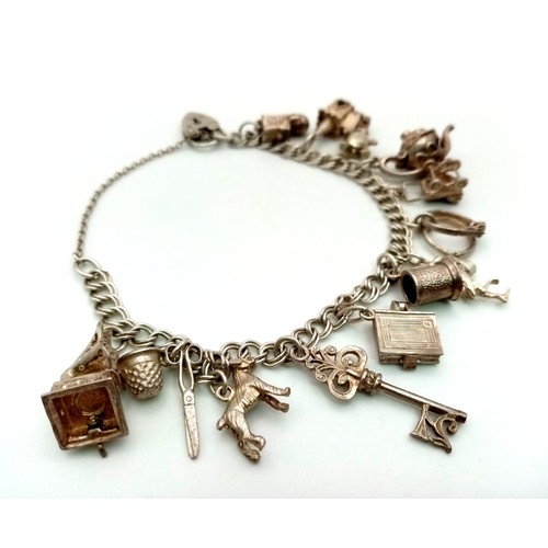 813 - A Vintage 925 Silver Charm Bracelet with Heart Clasp and Twelve Charms. 37.7g total weight.