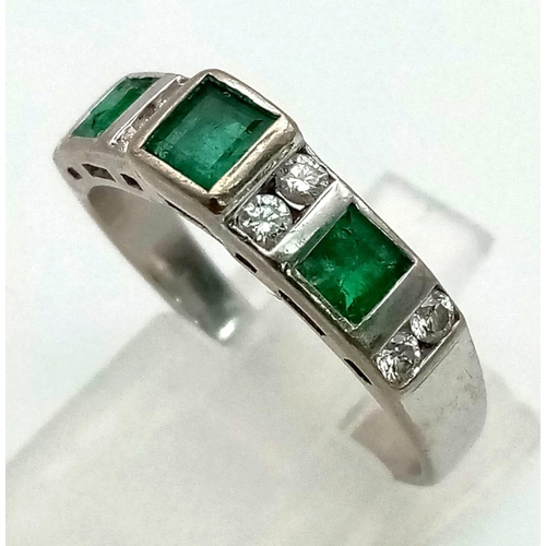 355 - An 18K White Gold Emerald and Diamond Ring. Three emeralds and eight diamonds complete the sequence.... 