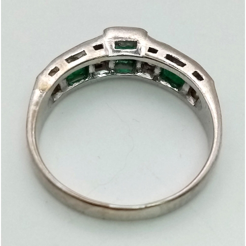 355 - An 18K White Gold Emerald and Diamond Ring. Three emeralds and eight diamonds complete the sequence.... 