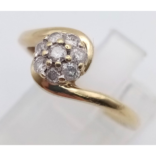 474 - A 9K Yellow Gold Diamond Cluster Crossover Ring. Eight diamonds. Size N. 2.23g total weight