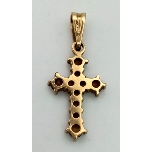 563 - A 9 K yellow gold cross with garnets. Dimensions (with bail): 25 x 10 x 2 mm , weight: 1 g.