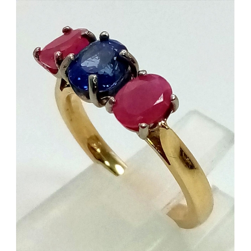 542 - An 18 K yellow gold ring with central blue sapphire and a ruby on either side. Ring size: M, weight:... 