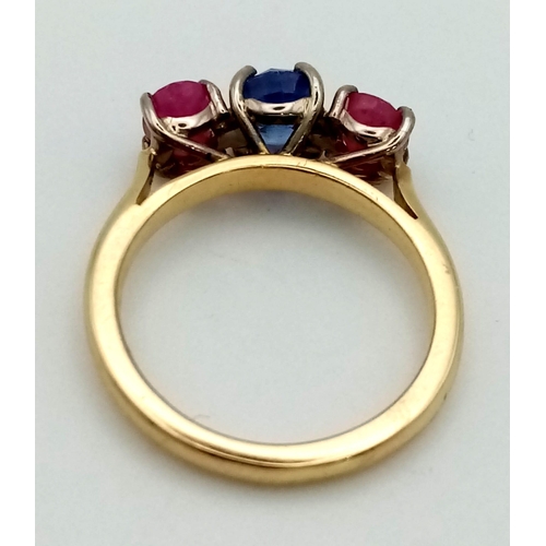 542 - An 18 K yellow gold ring with central blue sapphire and a ruby on either side. Ring size: M, weight:... 