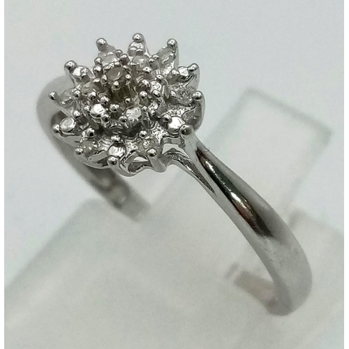 739 - A 9K White Gold Diamond Floral Cluster Ring. Size M. 1.63g total weight.