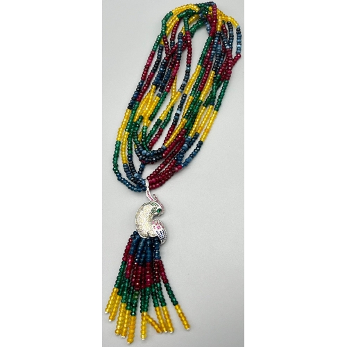 141 - A fabulous four strand necklace with rubies, emeralds, sapphires, citrine and a glorious exotic parr... 