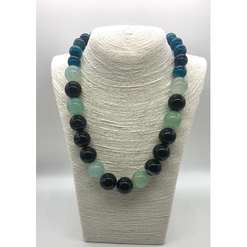 932 - A Multi-Coloured Onyx Bead Necklace. Blue, pale green and black beads 14-20mm.
48cm length. Comes in... 