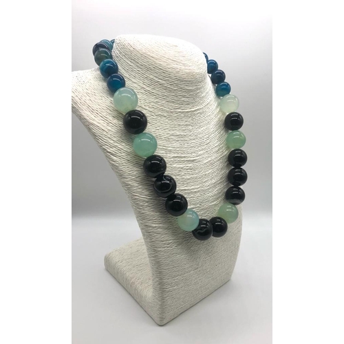 932 - A Multi-Coloured Onyx Bead Necklace. Blue, pale green and black beads 14-20mm.
48cm length. Comes in... 