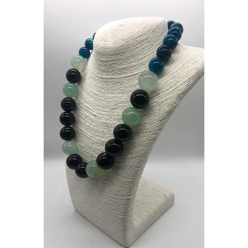 932 - A Multi-Coloured Onyx Bead Necklace. Blue, pale green and black beads 14-20mm.
48cm length. Comes in... 