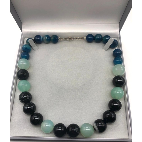 932 - A Multi-Coloured Onyx Bead Necklace. Blue, pale green and black beads 14-20mm.
48cm length. Comes in... 