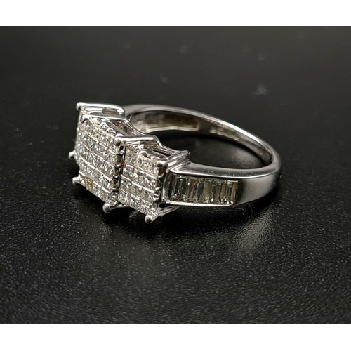 1017 - An 18K White Gold Princess-Cut Diamond Ring. Twenty brilliant white central diamonds with twelve dia... 