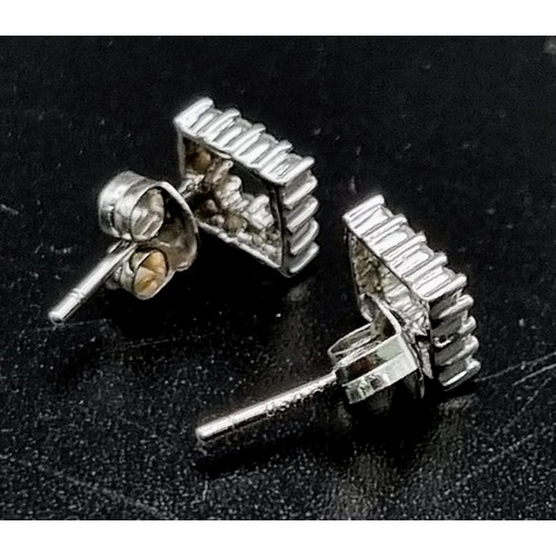 559 - An 18 K white gold pair of stud earrings with a square cluster of diamonds (0.25 carats). total weig... 