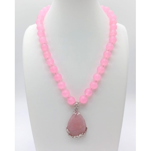 1128 - A Pink Quartz Bead Necklace and Teardrop Pendant. 10mm beads.
3.5 and 42cm.