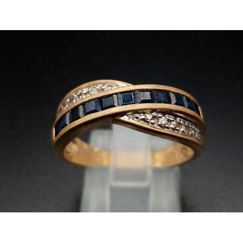 1484 - A 14K Yellow Gold Diamond and Sapphire Crossover Ring. Eleven square-cut sapphires crossed over by a... 