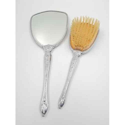 1440 - A Vintage Silver-Plate Hand Mirror and Hair Brush. Black back with ornate decoration. Mirror- 32cm. ... 