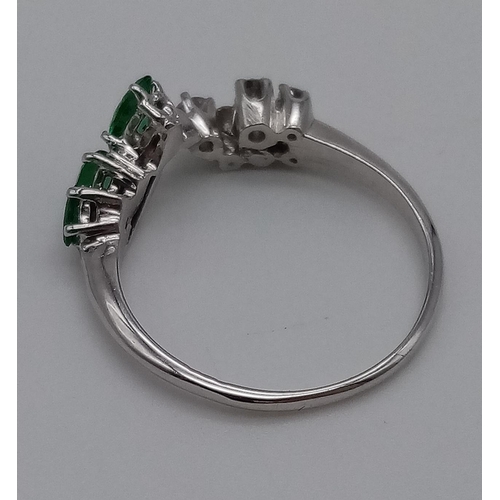 379 - A 9K White Gold Chevron Emerald and Diamond Ring. 3 Emeralds and 7 Diamonds. Size R. Total weight: 2... 